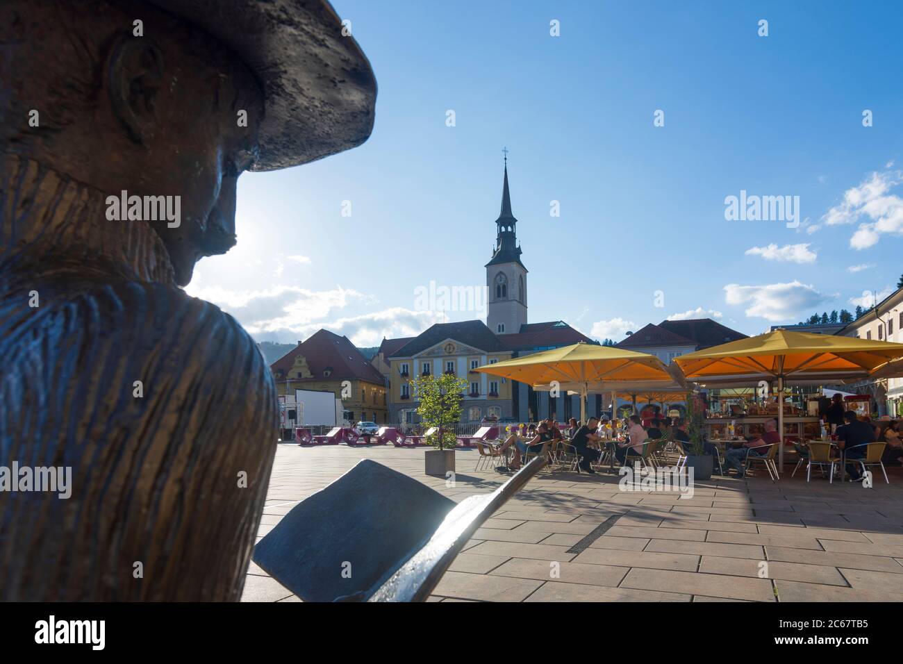 Bruck an der Mur: Piazza principale Koloman-Wallisch-Platz, scultura 'Stadtnachrichten', chiesa parrocchiale di Murau-Murtal, Steiermark, Stiria, Austria Foto Stock