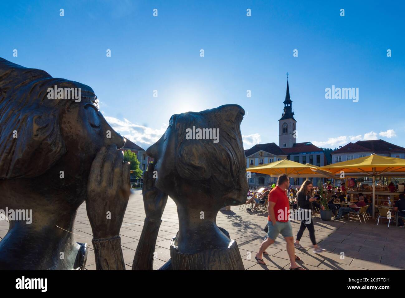 Bruck an der Mur: Piazza principale Koloman-Wallisch-Platz, sculture 'tadtgespräch' due donne che parlano l'una con l'altra, chiesa parrocchiale a Murau-Murtal, Steie Foto Stock