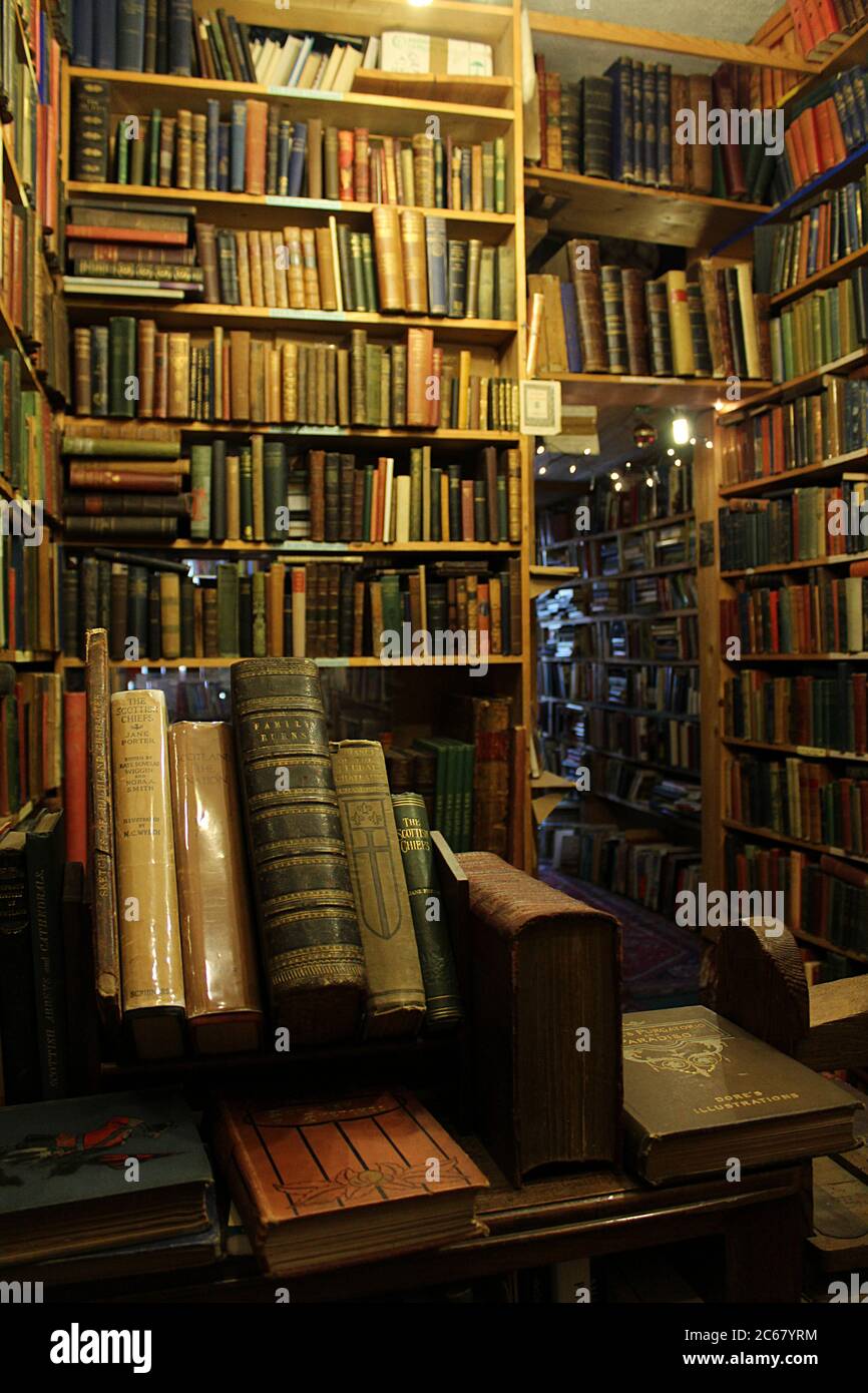 Negozio di libri di seconda mano e antiquario poltrone Libri nel Porto Ovest di Edimburgo, scaffali di libri da pavimento a soffitto con luci accoglienti, storia scozzese bo Foto Stock