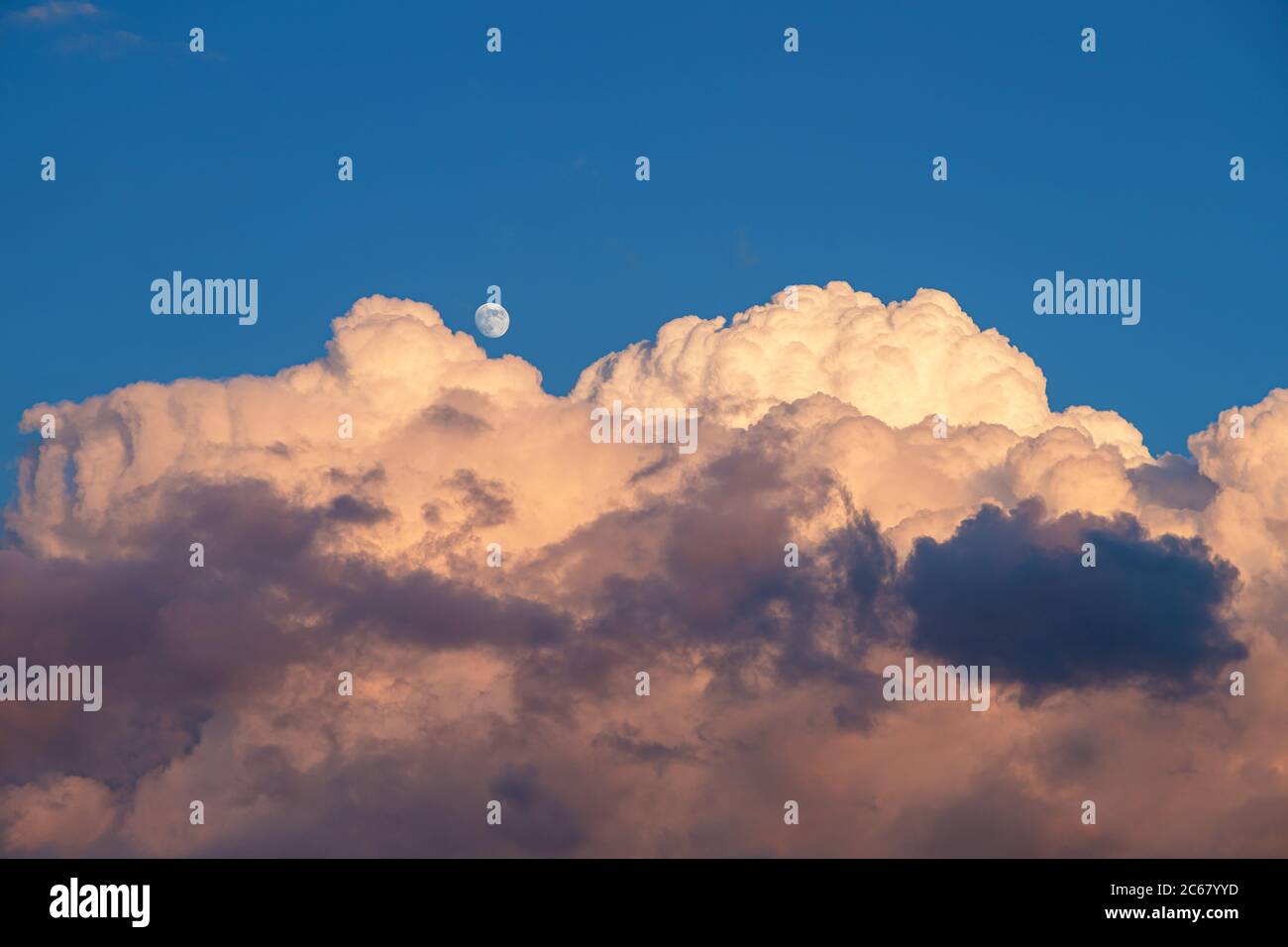 Luna piccola sopra la nuvola di tempesta, durante il giorno Foto Stock