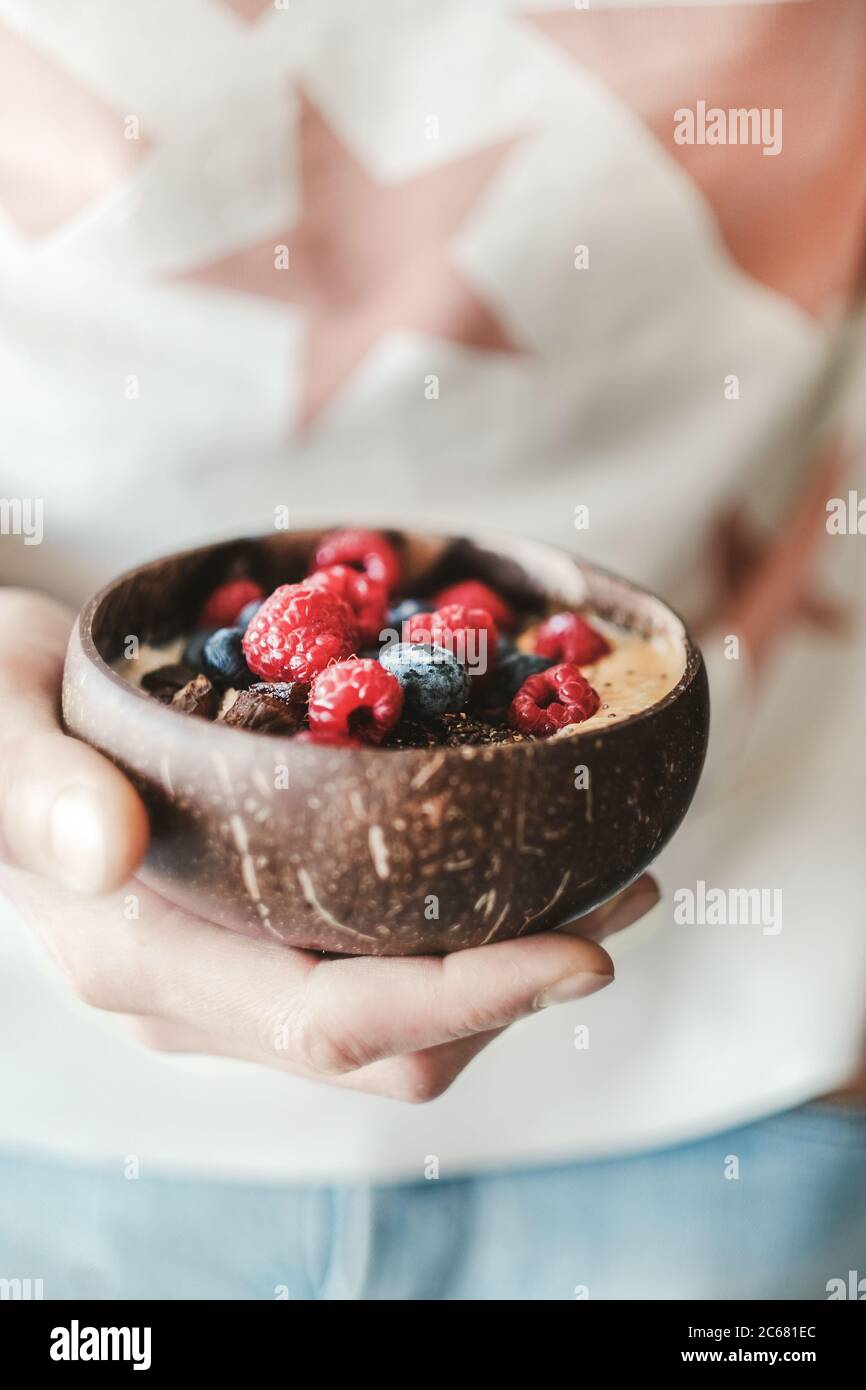Donna che tiene sana ciotola per la colazione con avena e frutta Foto Stock