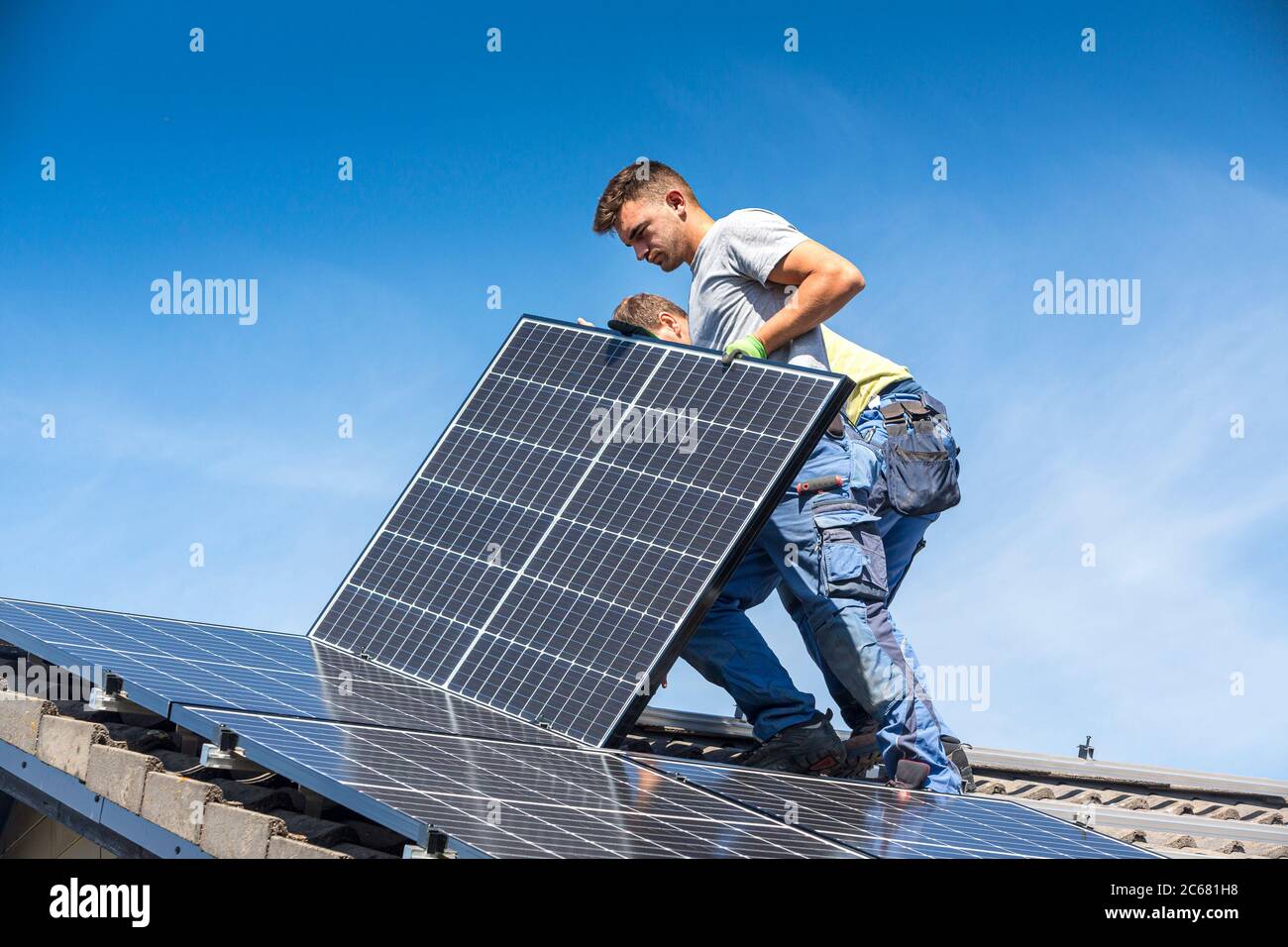 Installazione solare pannello fotovoltaico sistema. Pannello solare tecnico installazione di pannelli solari sul tetto. L'energia alternativa concetto ecologico. Foto Stock