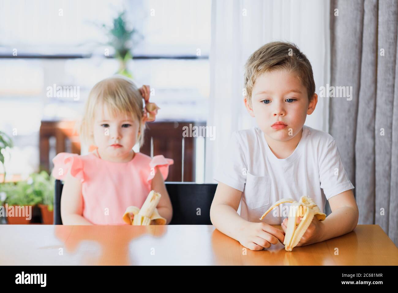 Una ragazza e un ragazzo che mangiano una banana Foto Stock