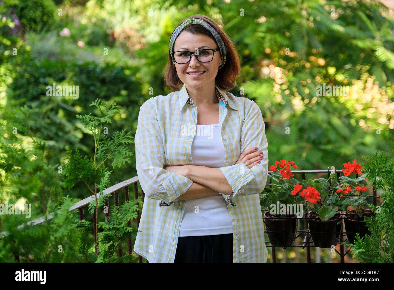 Ritratto di felice donna di mezza età, sicura donna sorridente con braccia ripiegate Foto Stock