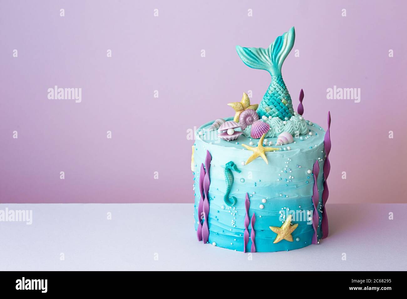 Torta di compleanno della sirena su sfondo viola Foto Stock