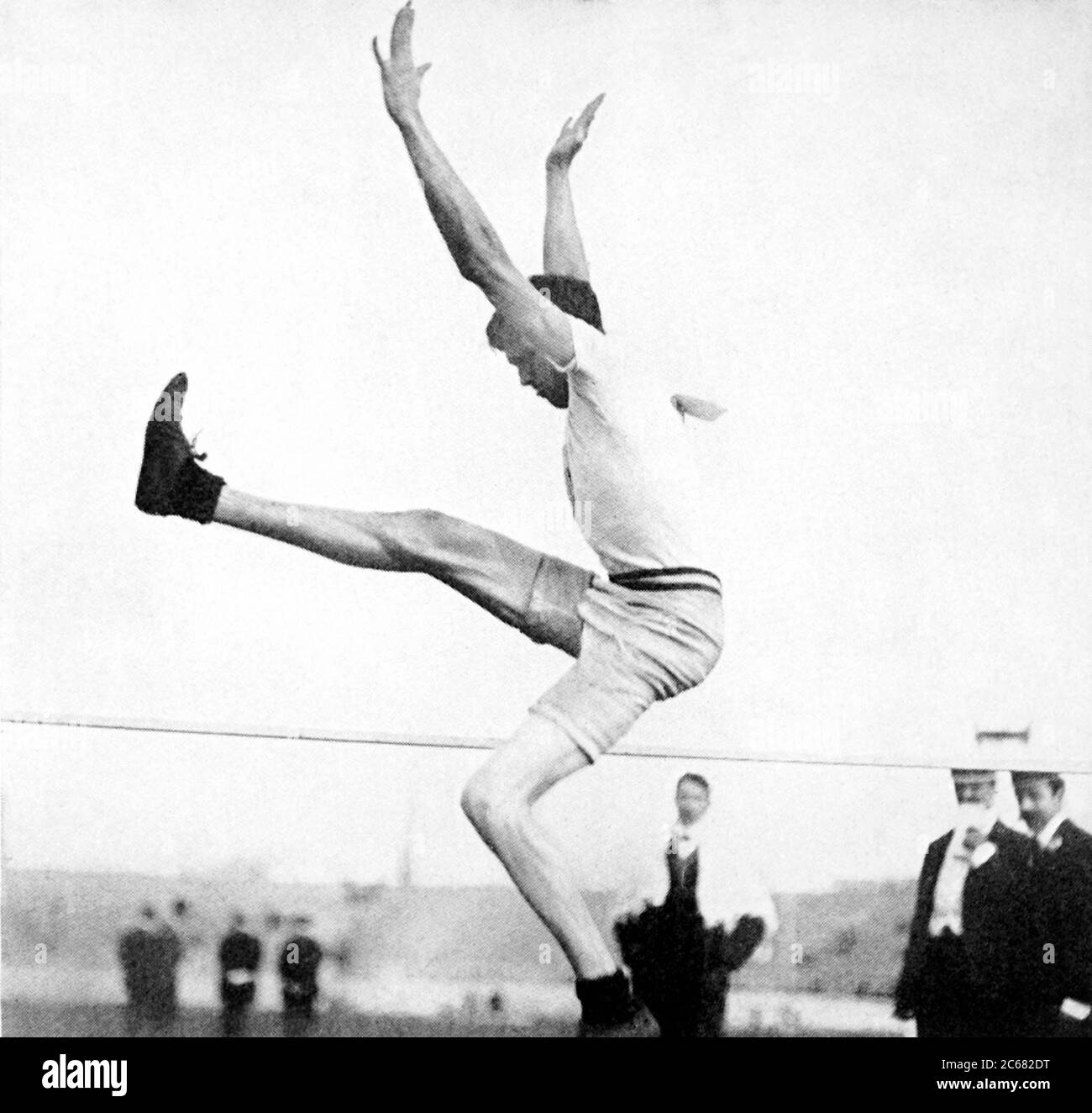 Londra, Inghilterra, Regno Unito. 23 luglio 1908. USA's RAY EWRY alza le braccia mentre si libera la barra per vincere l'oro per il Men's Standing High Jump durante i Giochi Olimpici di Londra 1908. Questa è la decima medaglia d'oro olimpica di Ewry in tutto. Credit: EMPICS/PA Wire/ZUMAPRESS.com/Alamy Live News Foto Stock
