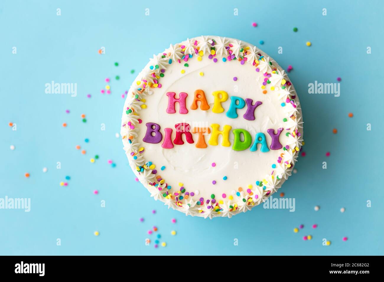 Torta di compleanno felice con lettere arcobaleno Foto Stock