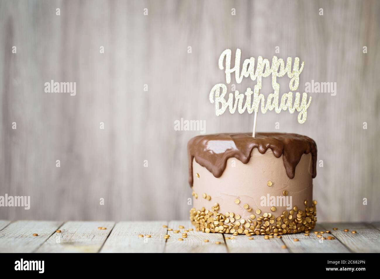 Torta di compleanno decorata con ganache al cioccolato e banner di compleanno Foto Stock