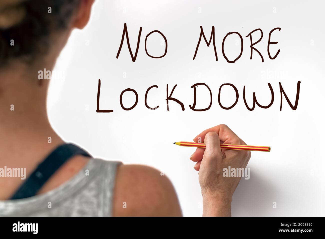 Mano femminile che scrivono la frase No More Lockdown su un white paper, indoor. Blocco del concetto di crisi finanziaria e sociale Foto Stock