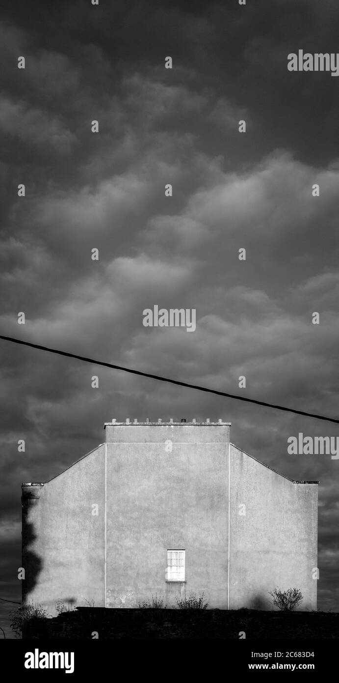 Costruzione di mura sotto il cielo drammatico, Irlanda Foto Stock