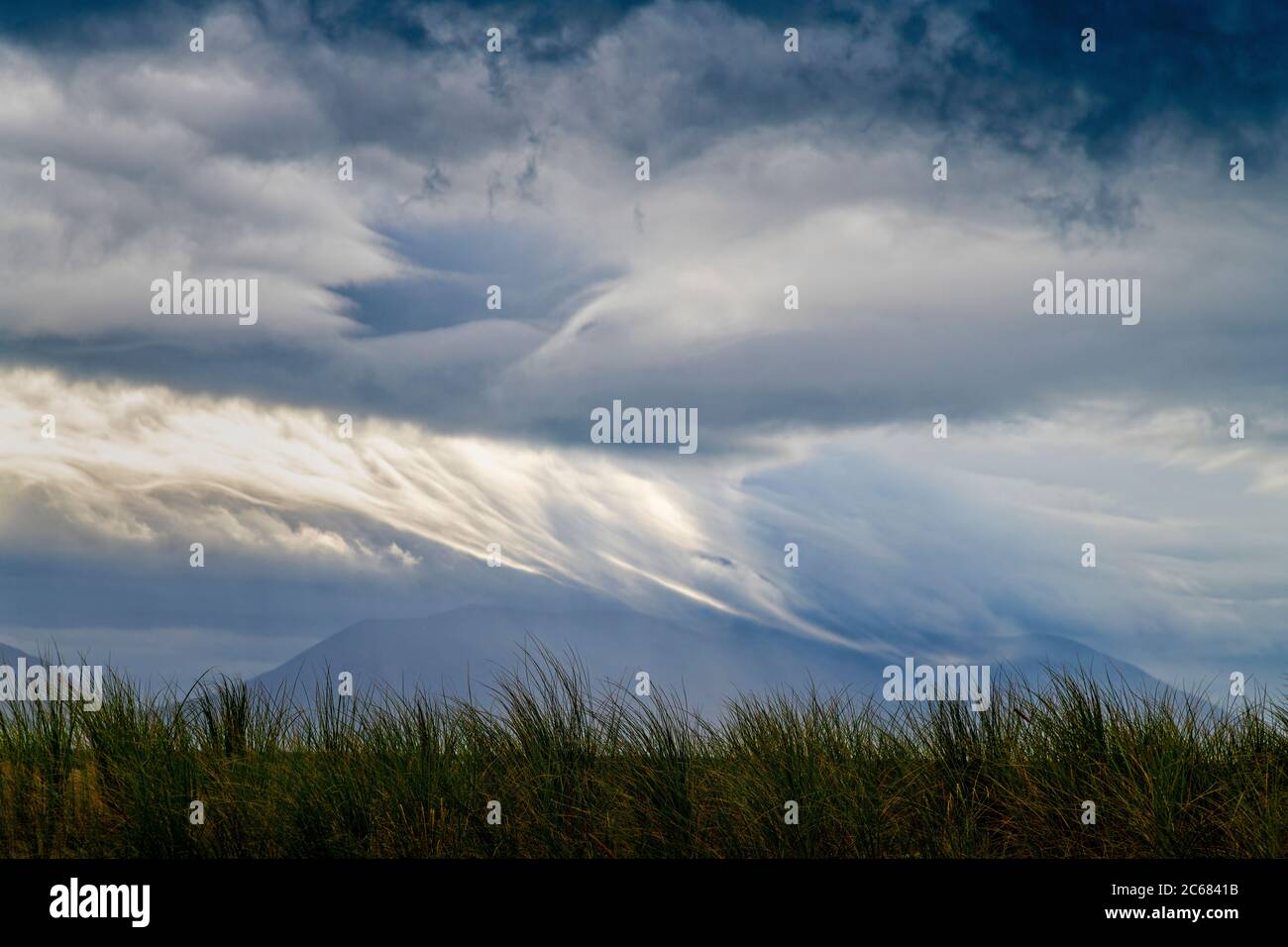 Nuvole tempesta e erba sulle dune di Inch Beach sulla penisola di Dingle, Inch, County Kerry, Irlanda Foto Stock