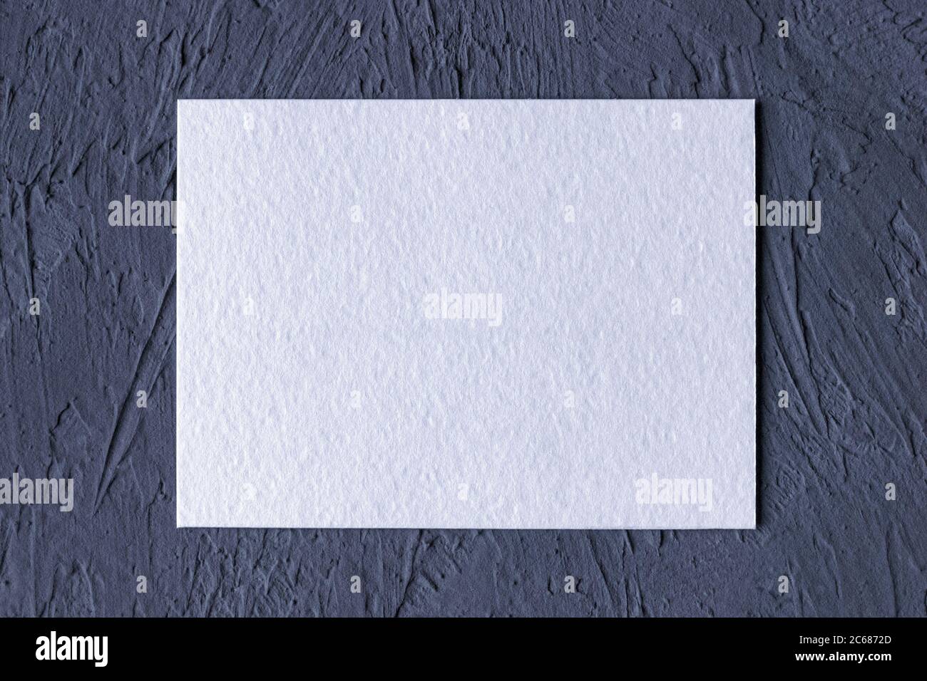 cartoncino di carta bianco su sfondo pieno grigio scuro Foto Stock