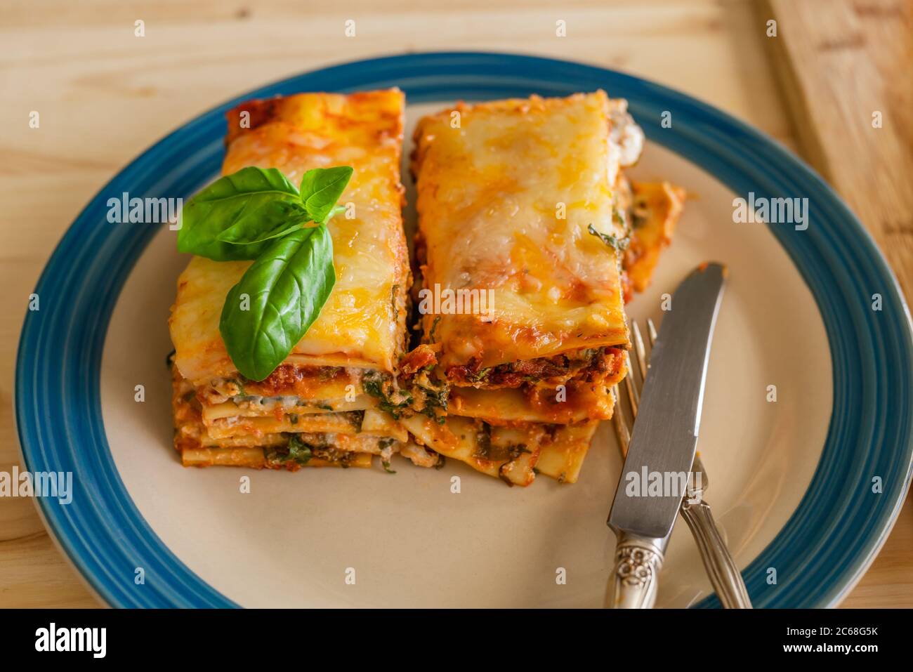 Lasagna spinaci. Deliziosa lasagna di spinaci fatta in casa con formaggio a strati tra le sfoglie primo piano su un piatto, vista dall'alto Foto Stock