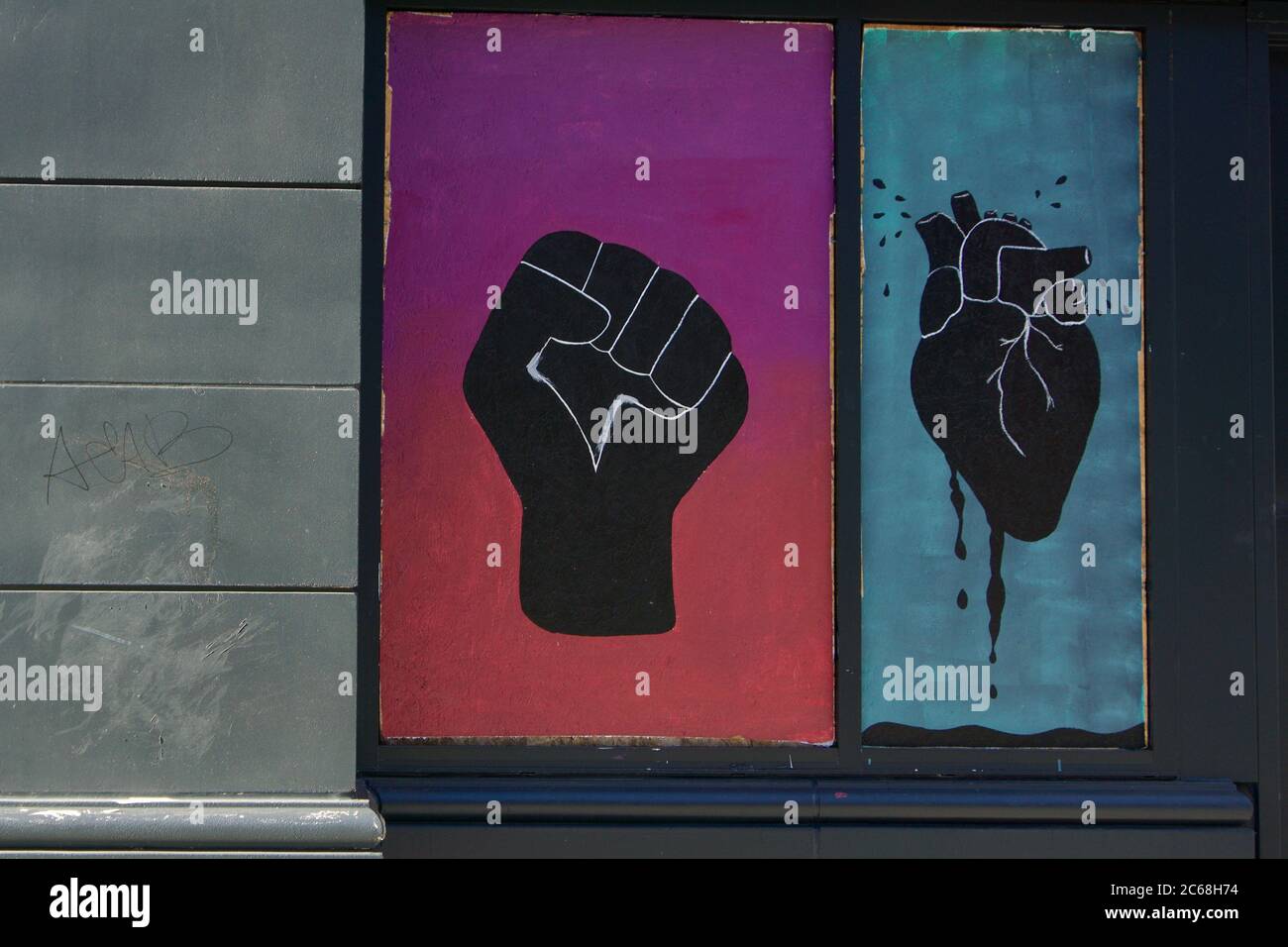 Black Lives importa Street art di un pugno nero dipinto e cuore nero gocciolante sulle finestre a bordo nel centro di Oakland dopo le proteste di George Floyd. Foto Stock