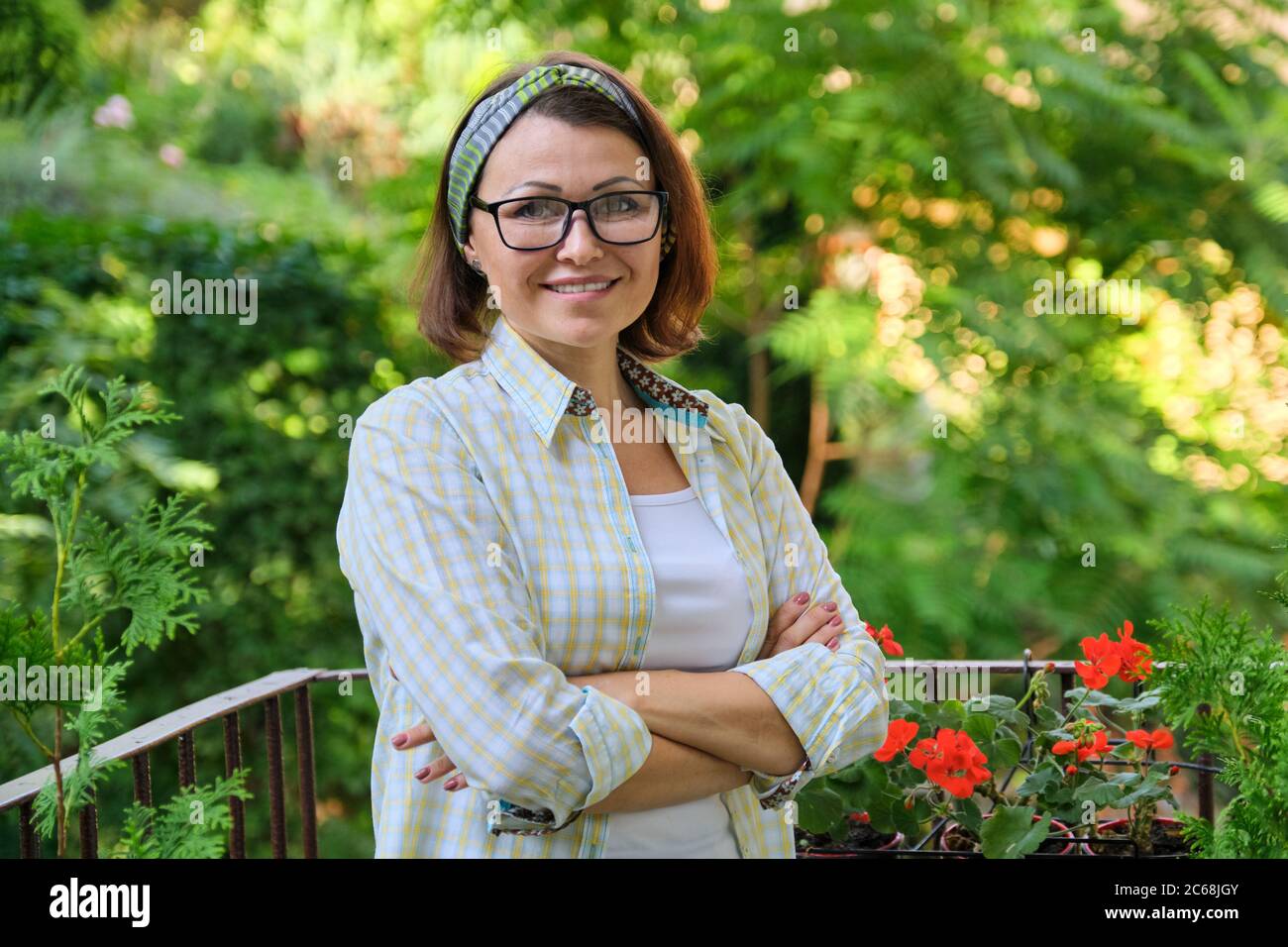Ritratto di felice donna di mezza età, sicura donna sorridente con braccia ripiegate Foto Stock