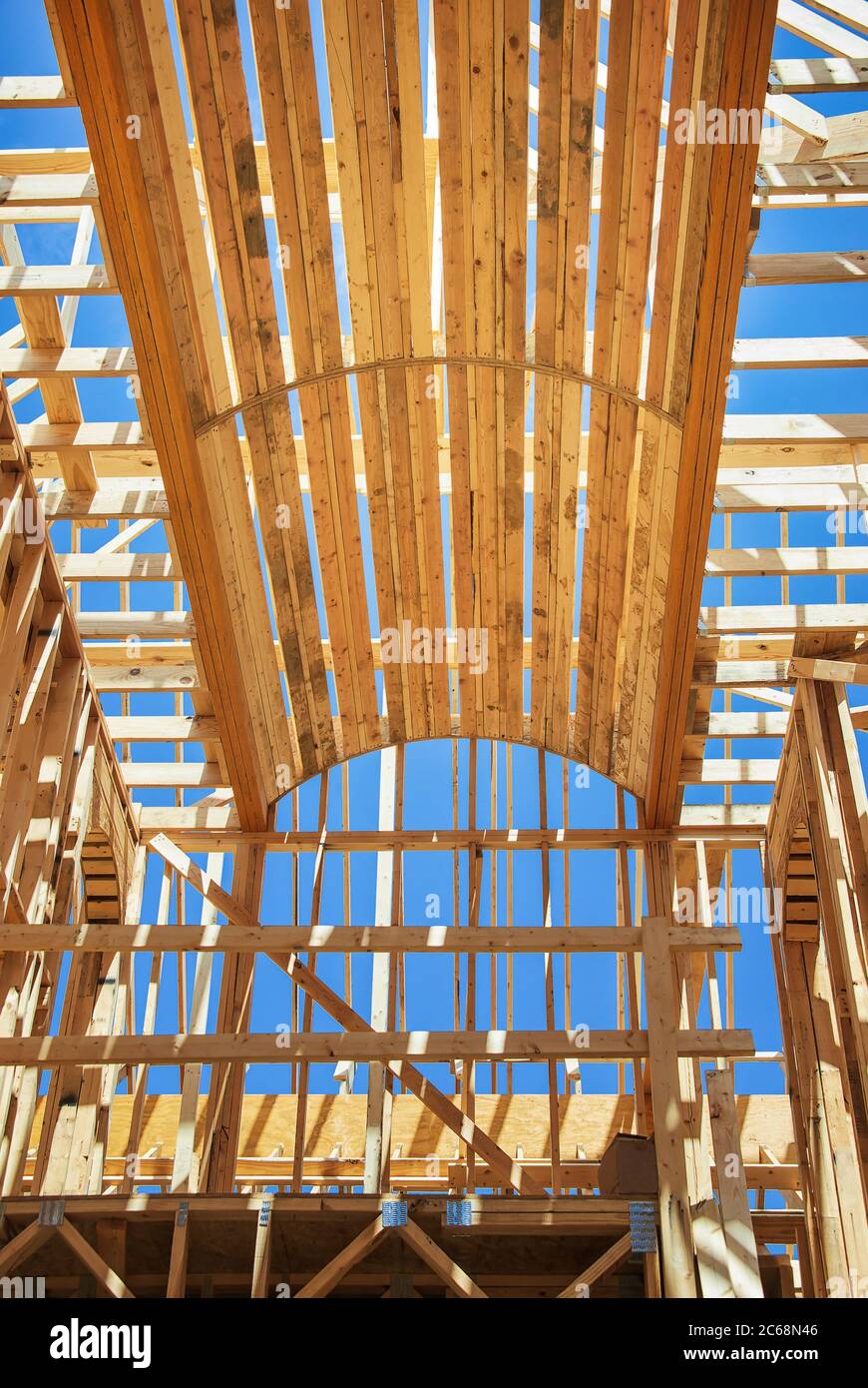 Nuova costruzione di cornici casa contro cielo blu. Dettagli su struttura ad arco e telaio del soffitto sopra il corridoio. Foto Stock