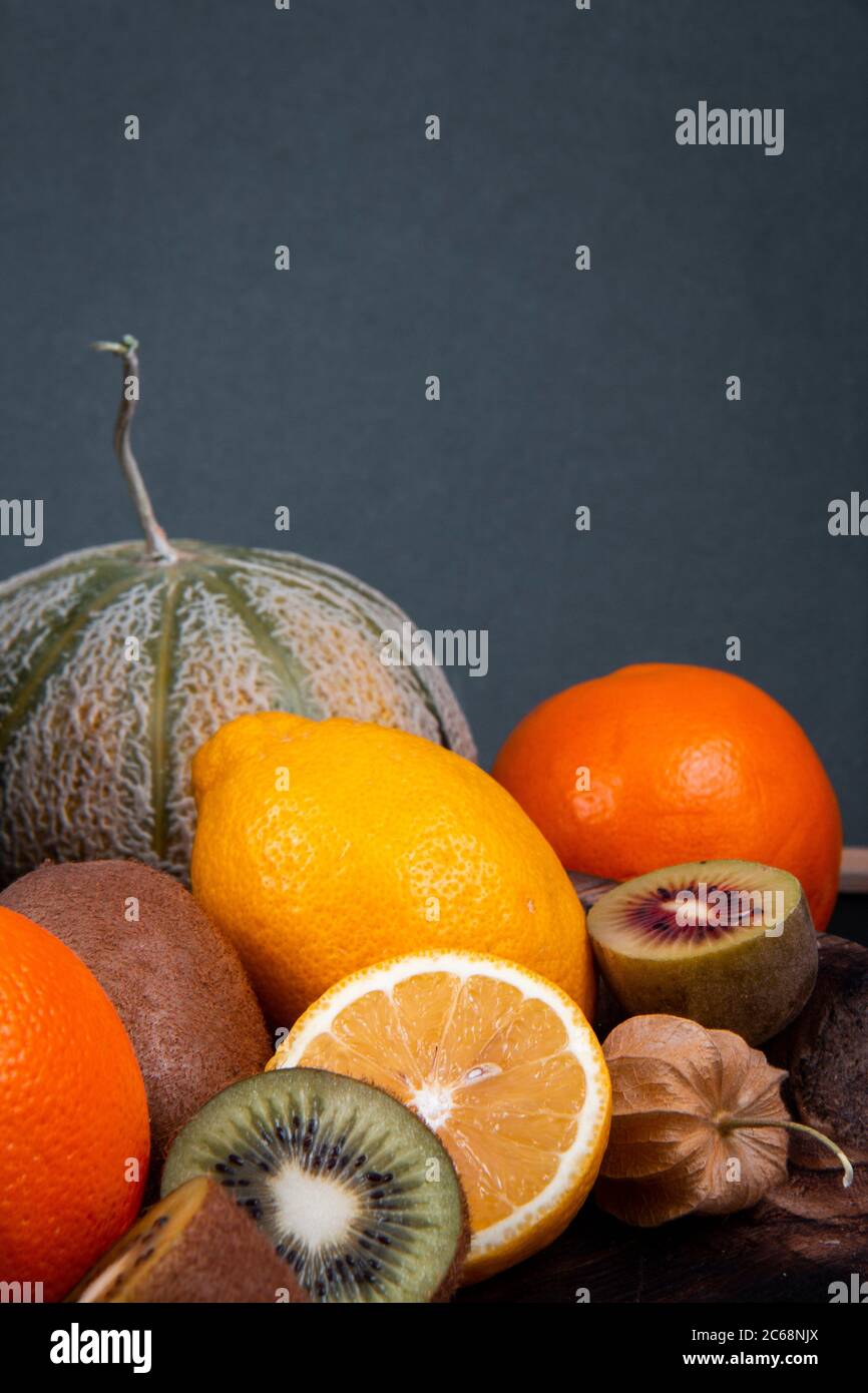 Kiwi tritati verdi e dorati, metà arancioni, meloni di melone e frutti di lanterna cinesi. Foto Stock