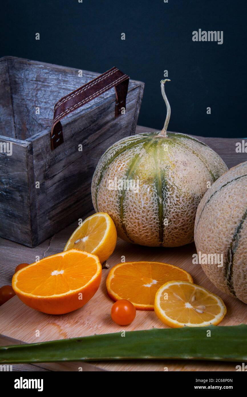 Fotografia di frutta commestibile: Arancio, melone di melone di miele, frutti di lanterna cinesi e una foglia verde di aloe vera. Foto Stock
