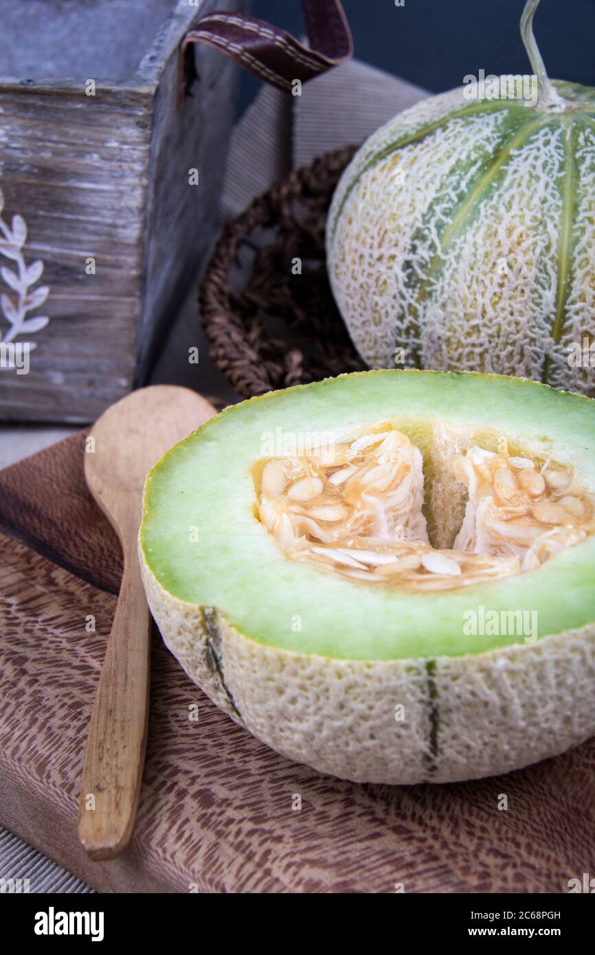 Una e mezza luna di miele verde su un tagliere. Foto Stock