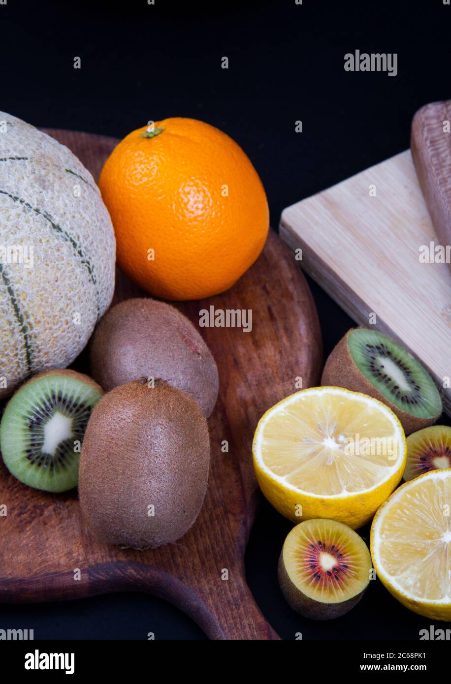 Arance, kiwi verdi e oro, limoni acari un melone grande di honeydew. Foto Stock