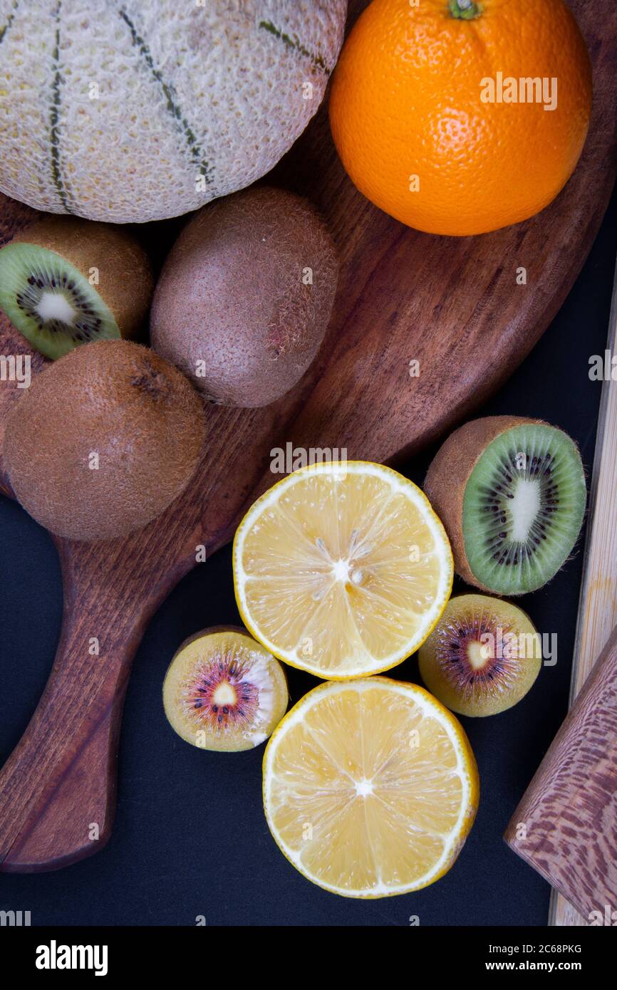 Arance, kiwi verdi e oro, limoni acari un melone grande di honeydew. Foto Stock