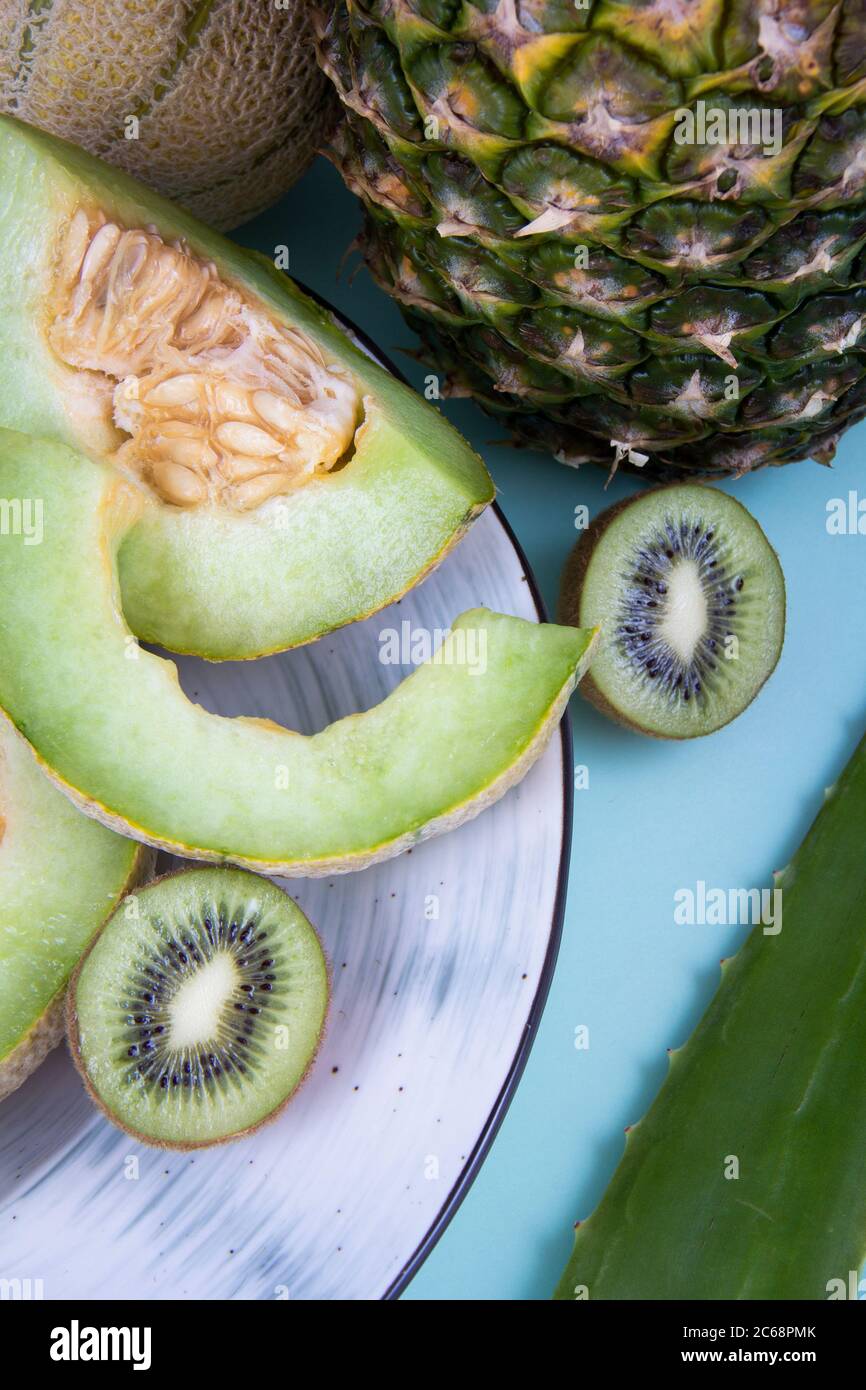 Fotografia di frutta commestibile: Ananas, kiwifras verde, meloni di melone di miele e una foglia di aloe vera. Foto Stock