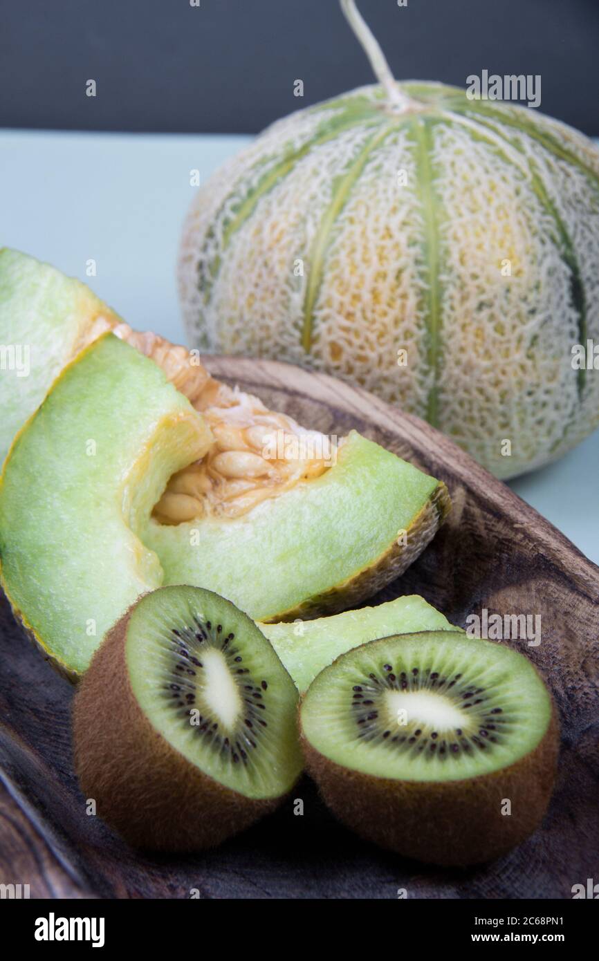 Meloni dolci di melone e kiwi freschi acidi vicini l'uno all'altro Foto Stock