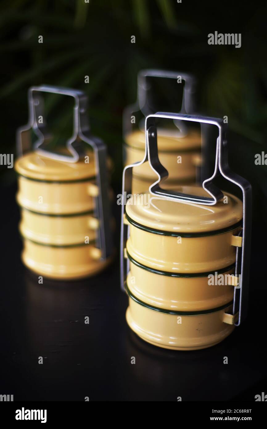 supporti tiffin gialli a 3 livelli su sfondo nero Foto Stock