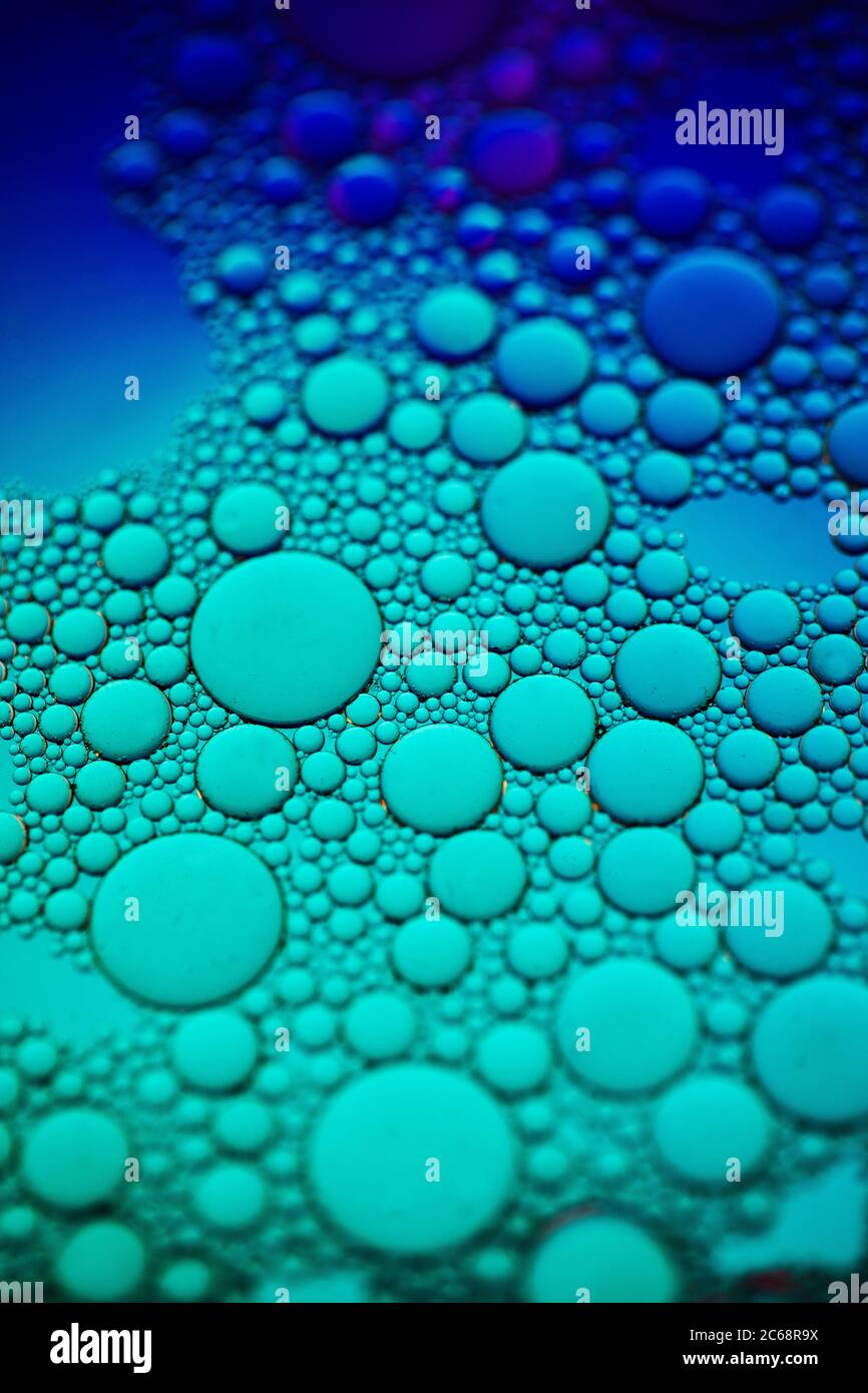 Bolle d'olio nell'acqua. Blu e verde. Foto Stock