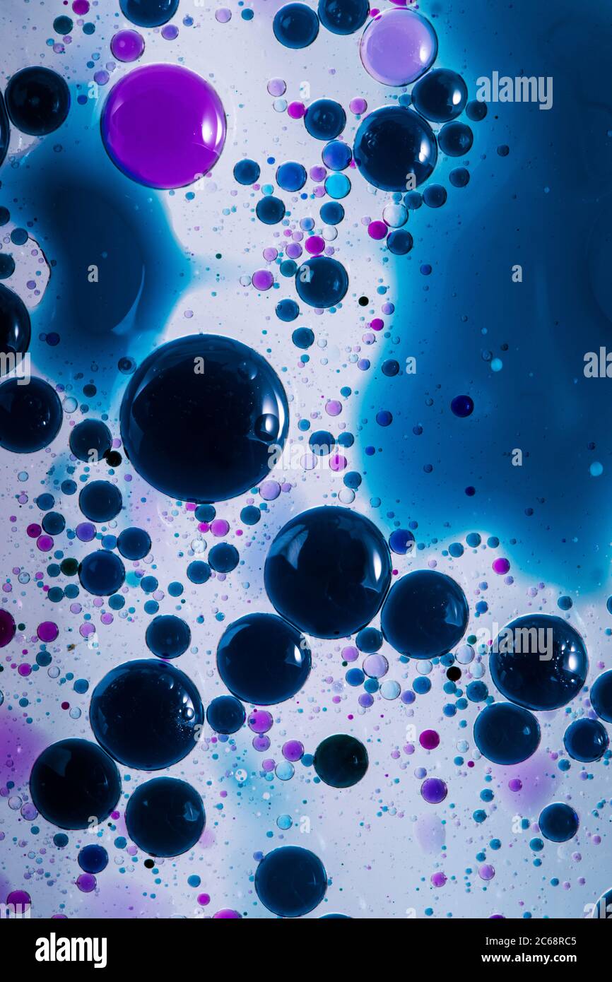 Bolle d'olio nell'acqua. Viola e nero insieme. Foto Stock