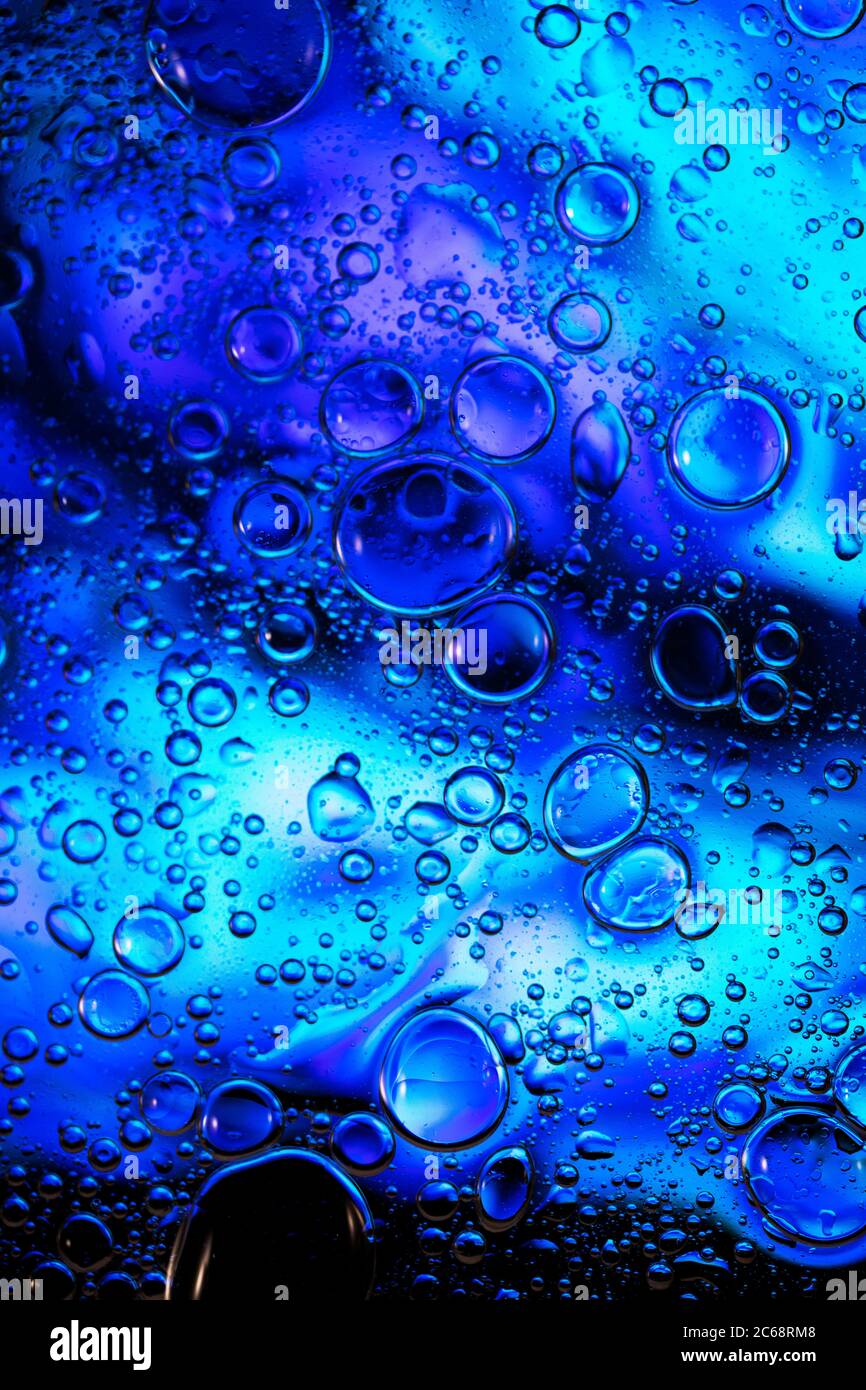 Bolle d'olio nell'acqua. Blu e nero insieme. Foto Stock