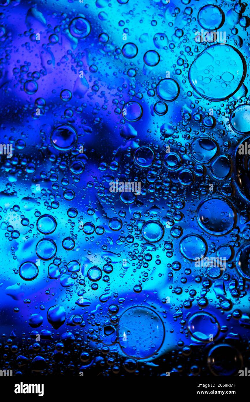 Bolle d'olio nell'acqua. Colori blu e nero. Foto Stock