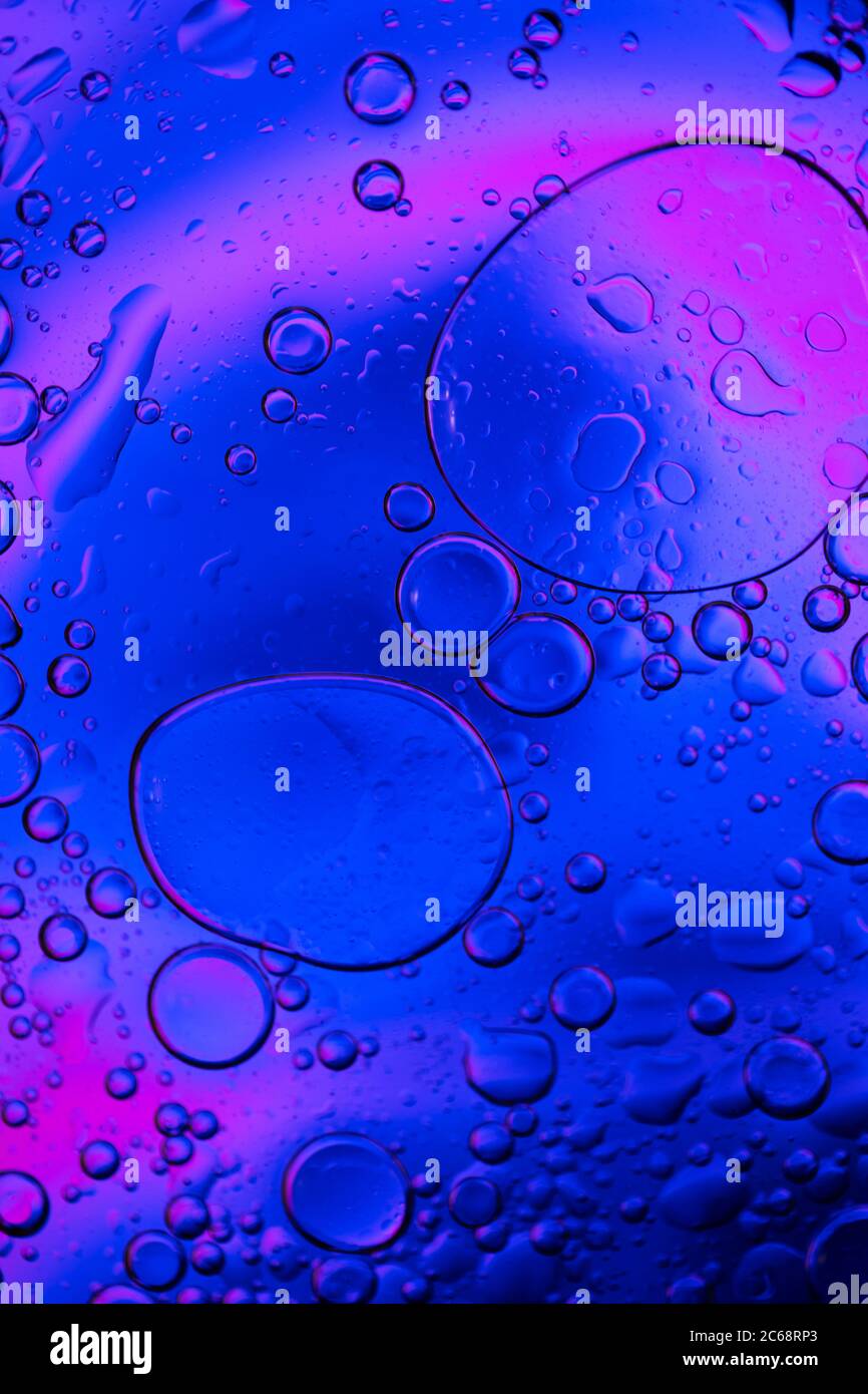 Bolle d'olio nell'acqua. Colori blu e viola. Foto Stock
