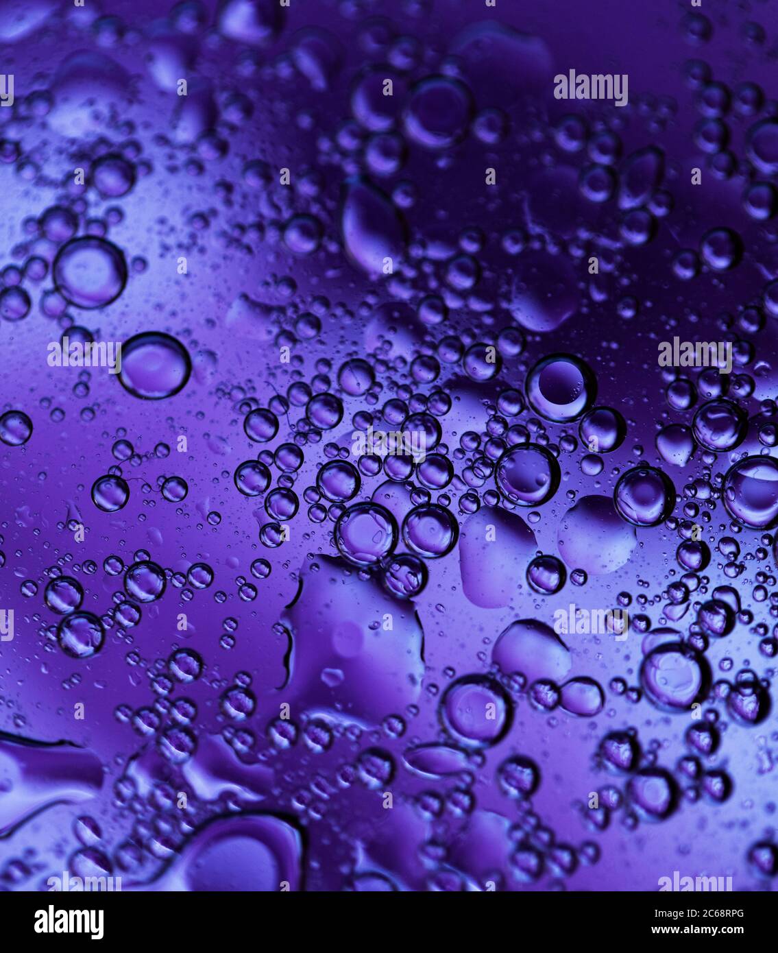 Bolle d'olio nell'acqua. Colori nero e viola. Foto Stock