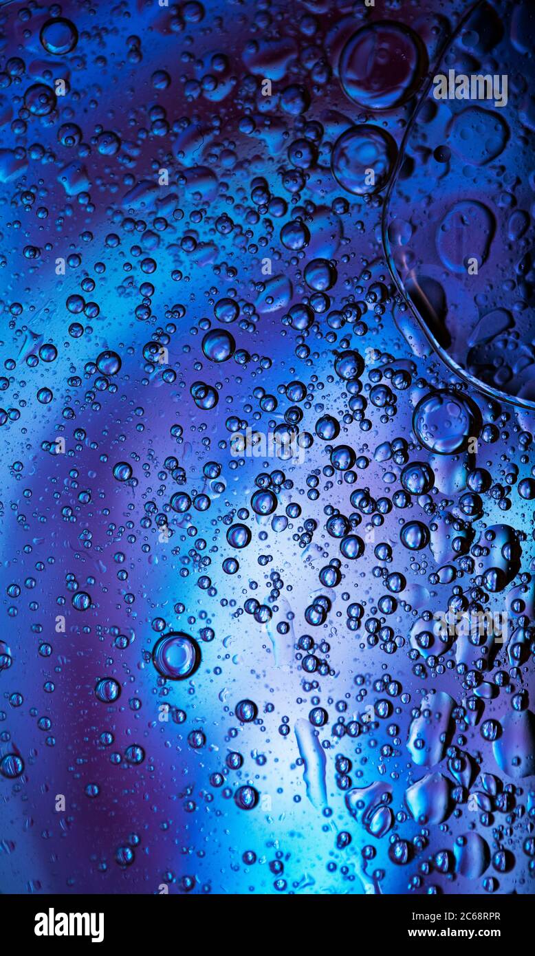 Bolle d'olio nell'acqua. Blu e nero Foto Stock
