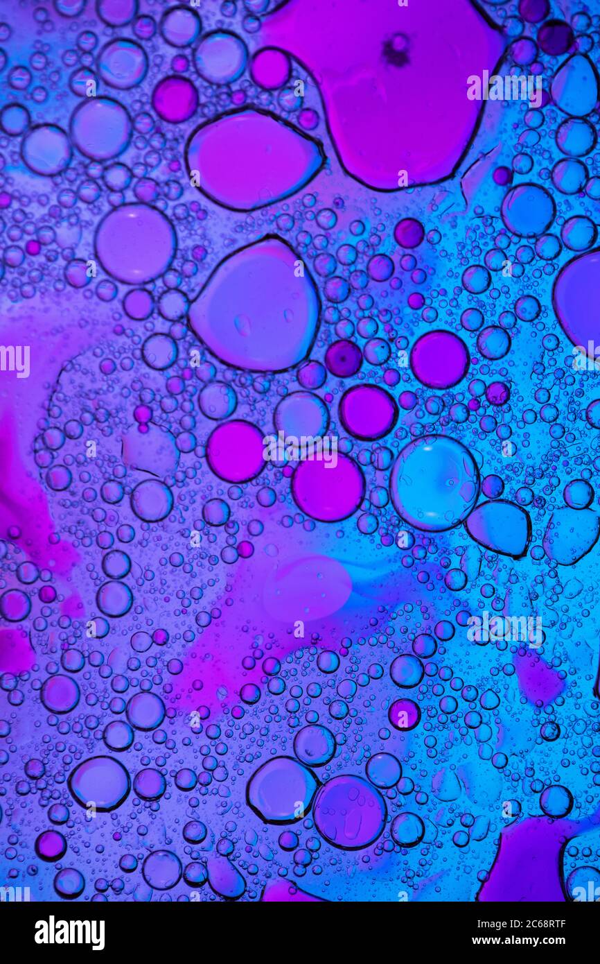 Bolle d'olio nell'acqua. Colori blu e viola. Foto Stock