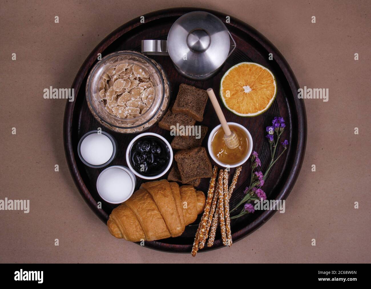 Un perfetto tavolo per la colazione a base di frutta fresca: E arancia, diversi tipi di pane: Croissant, pane al sesamo e pane tostato, marmellata, bastoncini salati, uova Foto Stock