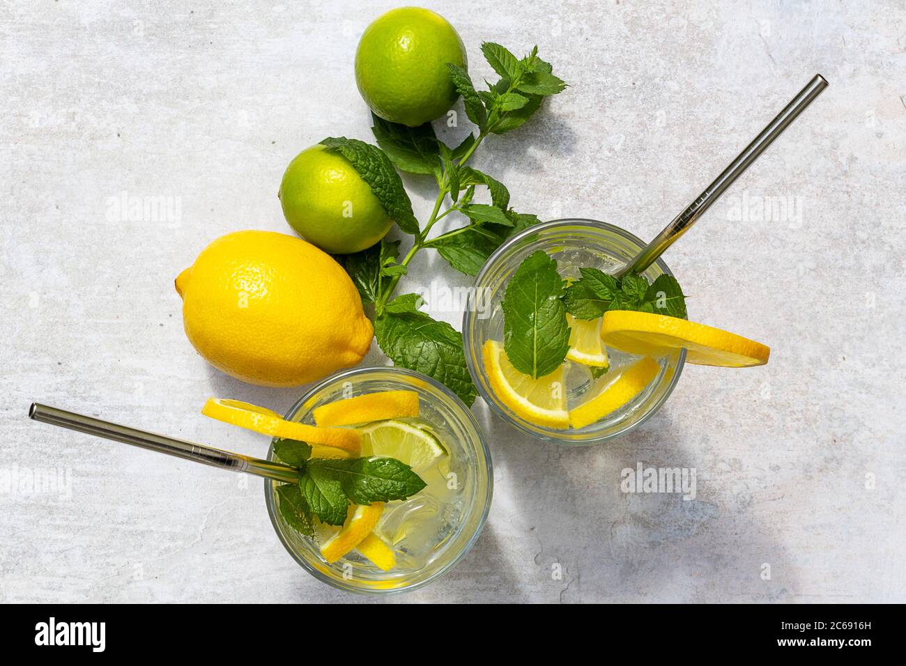 Vista dall'alto della rinfrescante limonata estiva fatta in casa con limone, fette di lime, menta e cubetti di ghiaccio Foto Stock