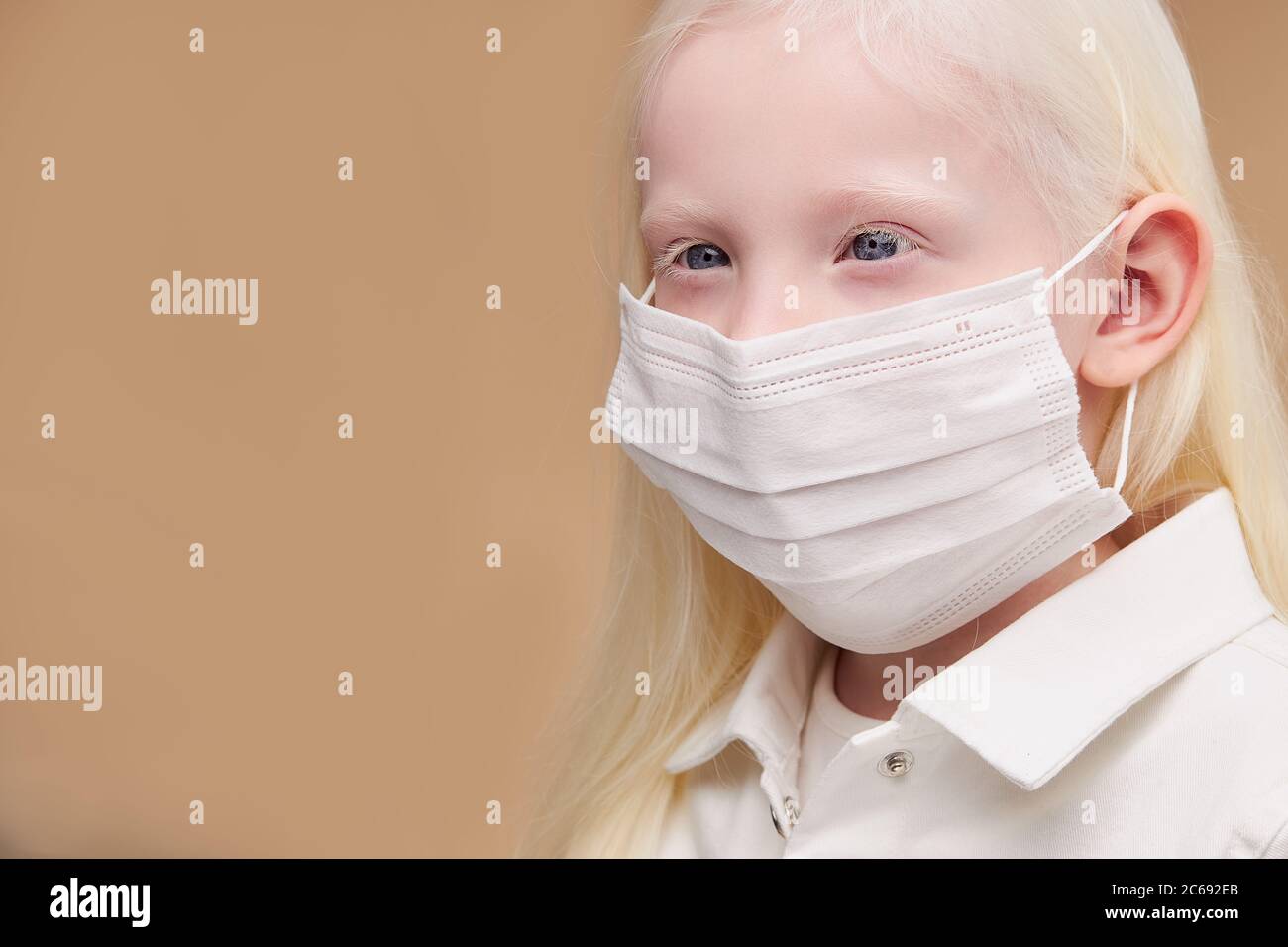 ritratto di bambino albino mistico malato in maschera medica isolata,  splendida ragazza con capelli assolutamente bianchi, ciglia, sopracciglia e  occhi blu stanno guardando Foto stock - Alamy