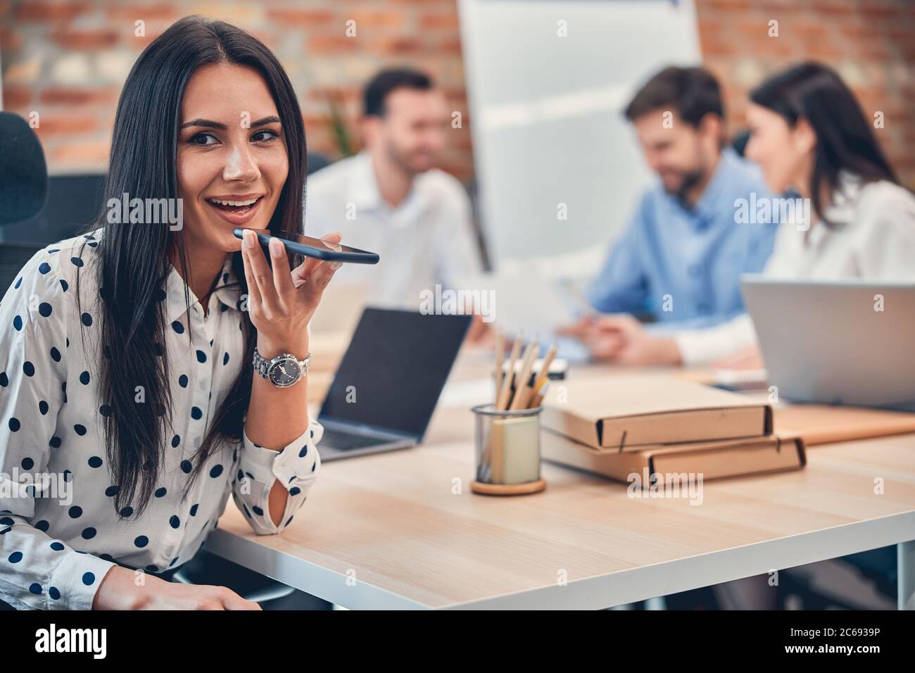Sorridente successo Signore surfing comando vocale sul suo telefono cellulare Foto Stock
