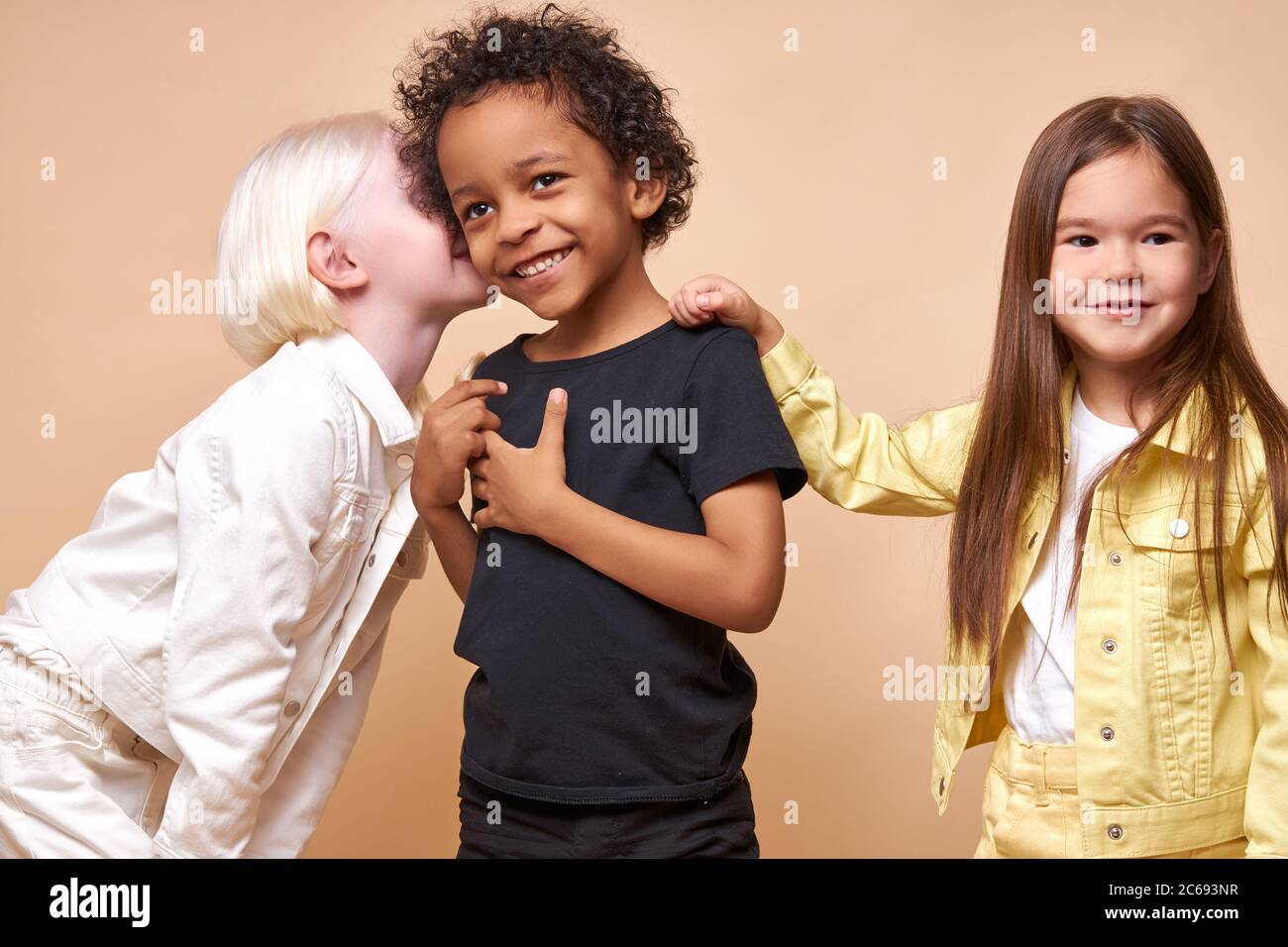 i bambini adorabili hanno segreti. i bambini diversi raccontano segreti nelle orecchie l'uno all'altro, condividono storie e mantengono il silenzio. emozioni, bambini conc Foto Stock