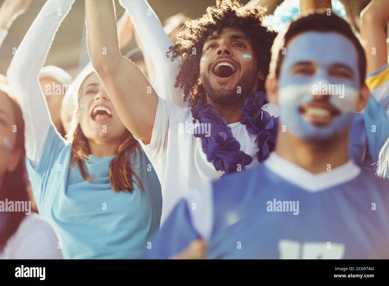 Gruppo di tifosi argentini di calcio. Eccitati gli appassionati di sport a giocare a calcio dal vivo e a fare il tifo per la loro squadra. Foto Stock