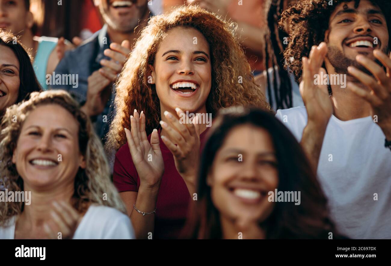 Gruppo di tifosi allo stadio che si acclamano al campionato di calcio. Entusiasti appassionati di sport che applaudono per la loro squadra dagli stand. Foto Stock