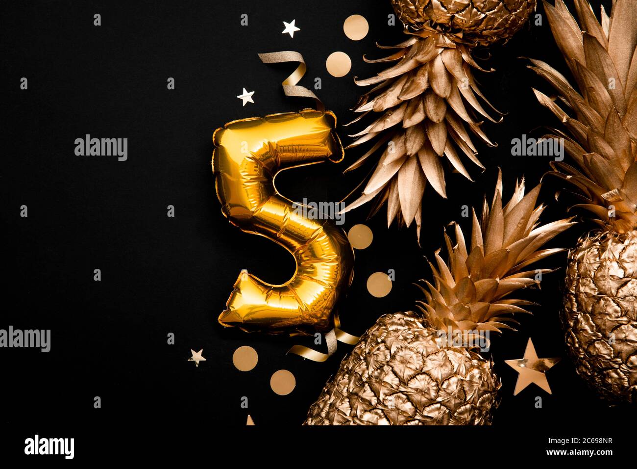 5 ° compleanno celebrazione sfondo con palloncini d'oro e ananas dorati Foto Stock