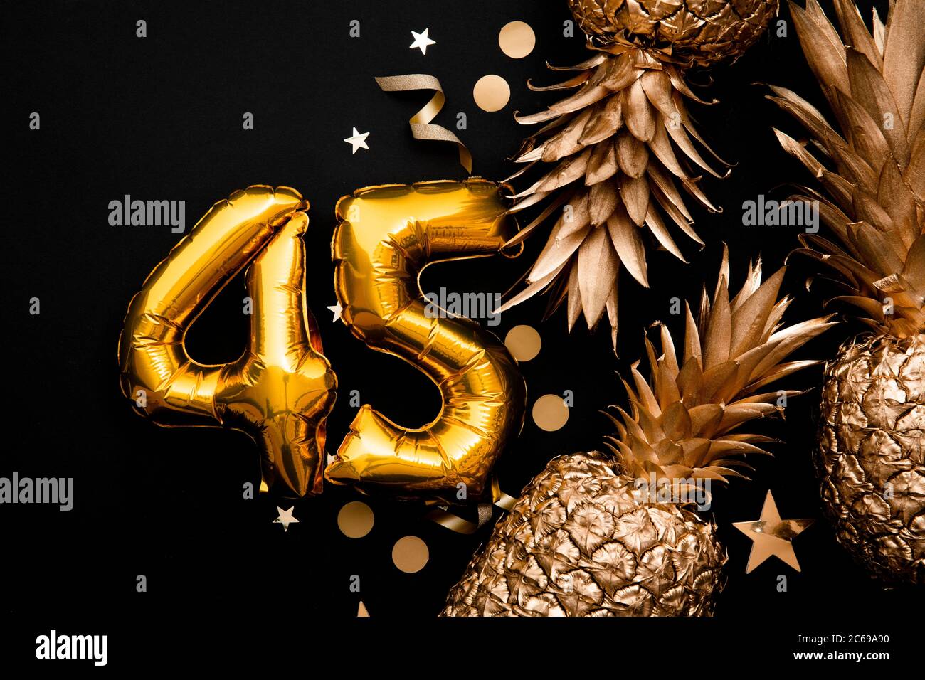 45 ° compleanno celebrazione sfondo con palloncini d'oro e ananas dorati Foto Stock