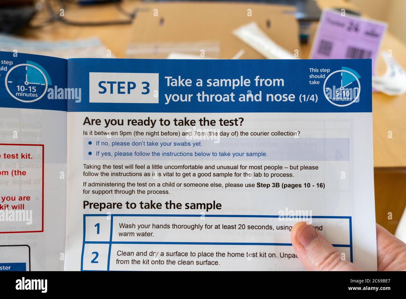 Istruzioni per il coronavirus (Covid-19) che accompagnano un kit di test per completare un test a casa tenuto dalle mani di un uomo e in fase di lettura, Regno Unito Foto Stock
