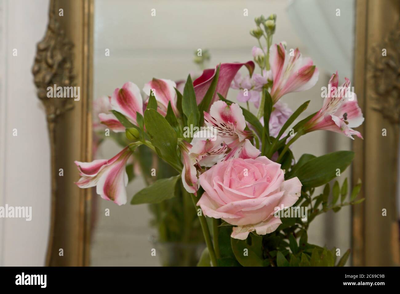 Un bouquet di fiori rosa diversi davanti a uno specchio Foto Stock