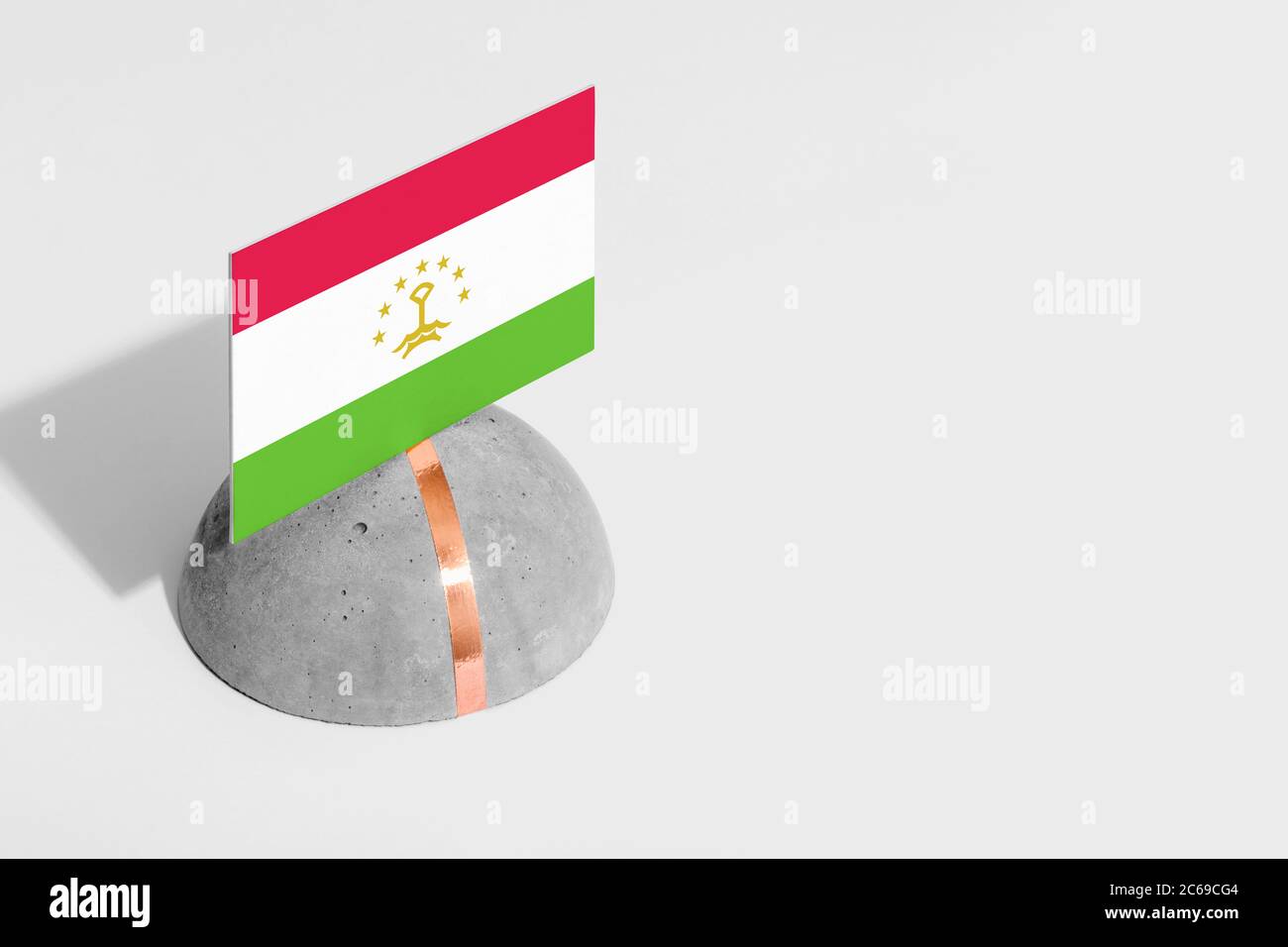 Bandiera del Tagikistan contrassegnata con pietra arrotondata. Sfondo bianco isolato. Vista laterale concetto nazionale minimo. Foto Stock