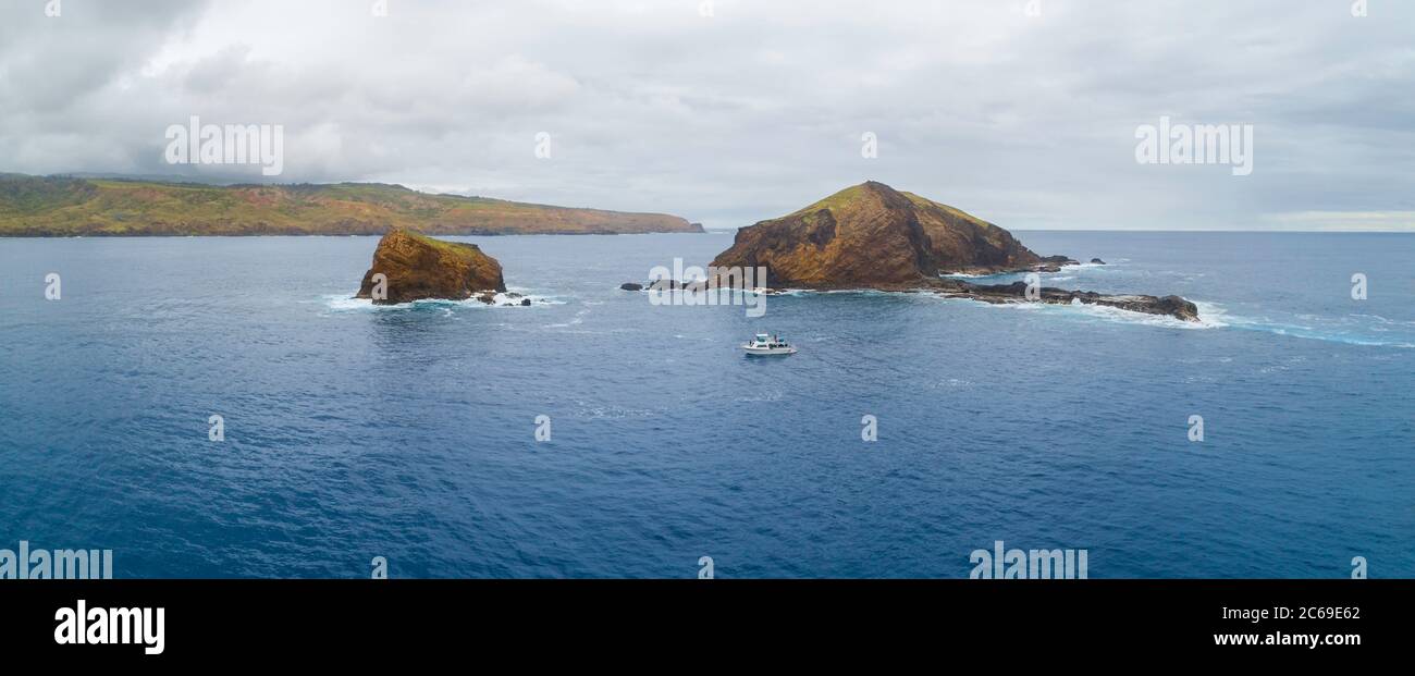 Una barca charter immersione al largo di MokuhoÕoniki Islet e Kanaha Rock vicino all'isola di Molokai, Maui County, Hawaii. L'estremità orientale dell'isola di Molokai è io Foto Stock
