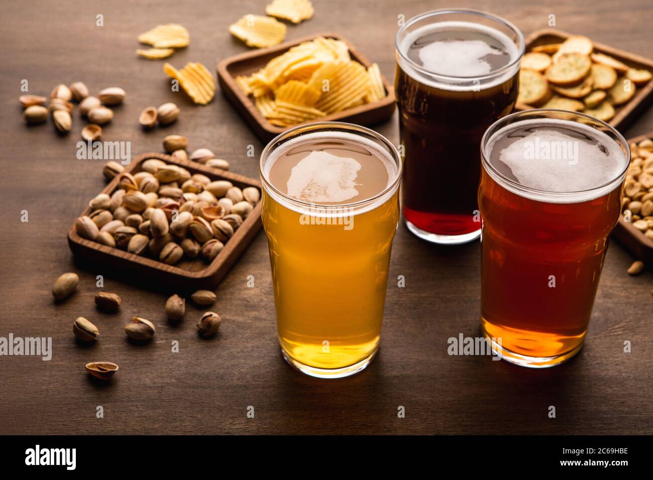 Tavolo per la compagnia di amici. Spuntini croccanti e diversi tipi di birra in bicchieri Foto Stock